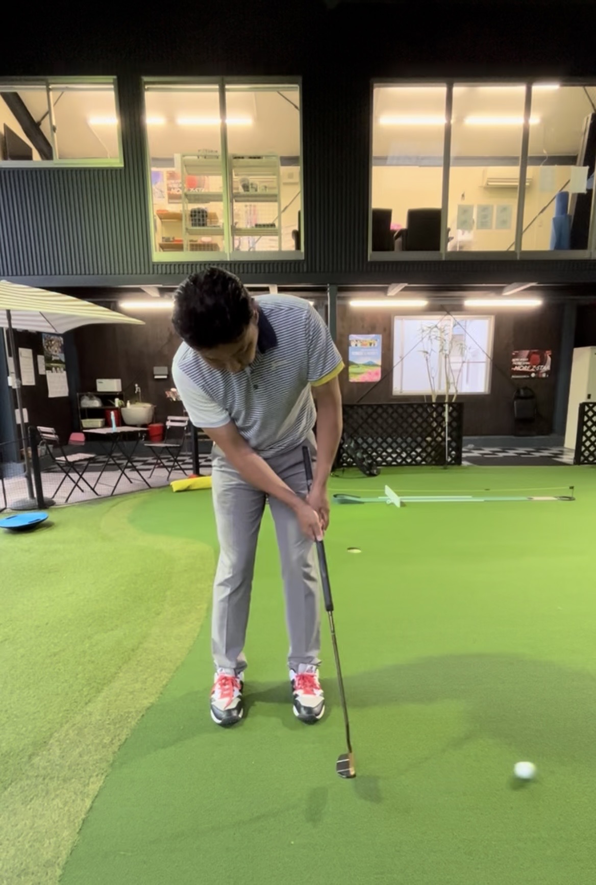 室内パター練習場でパッティングする様子